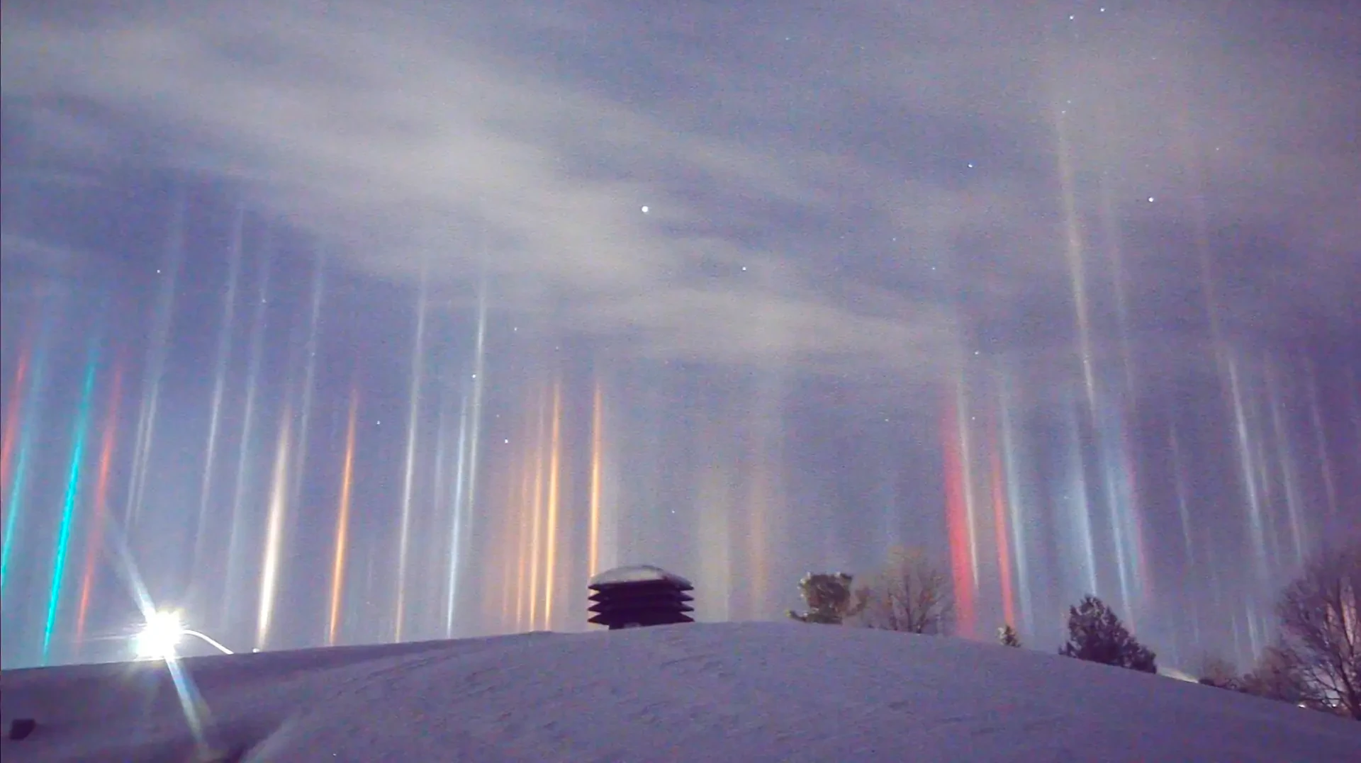 Foto zeigt Lichtsäulen in verschneiter Winterlandschaft